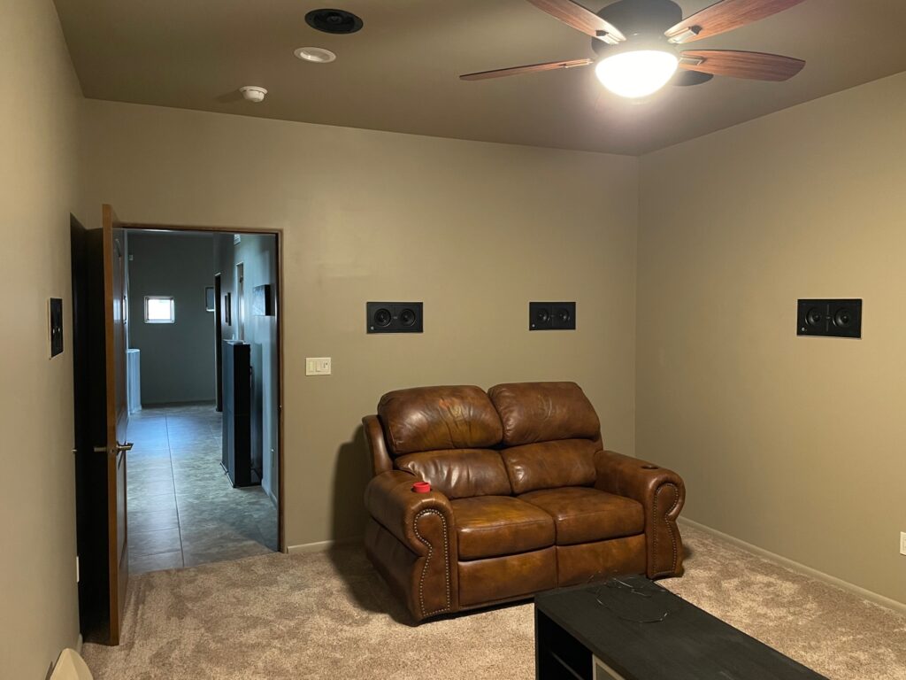 The back of the room showing the positions of the in-wall surround speakers and loveseat.